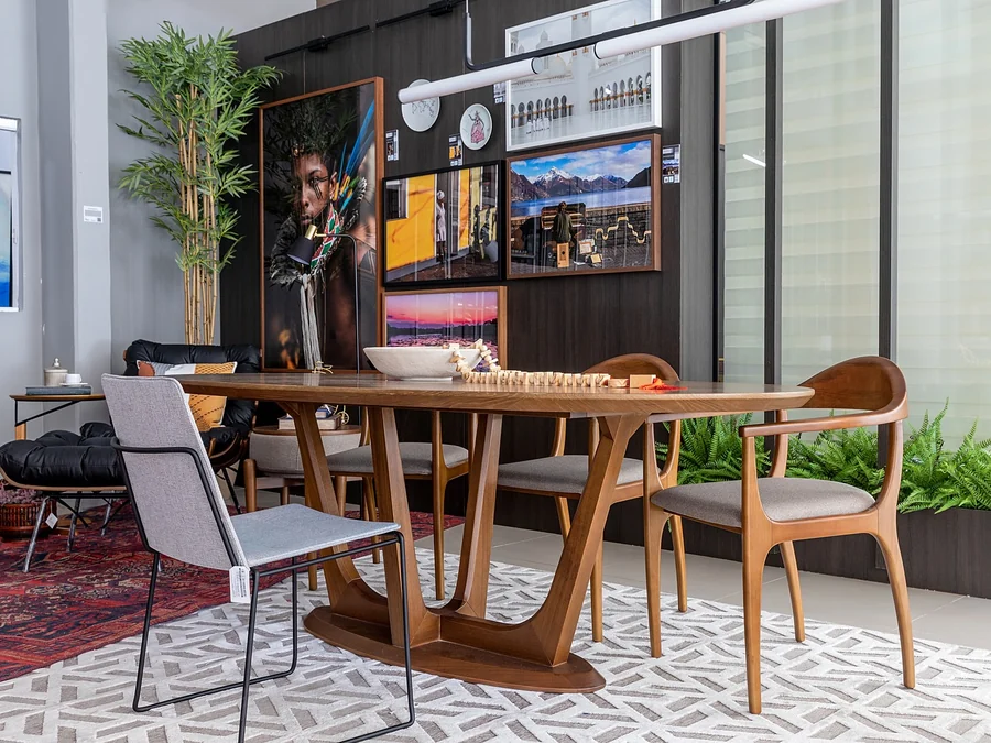 Sala de jantar do Espaço do Colecionador, com mesa de madeira, cadeiras e a poltrona laranja.