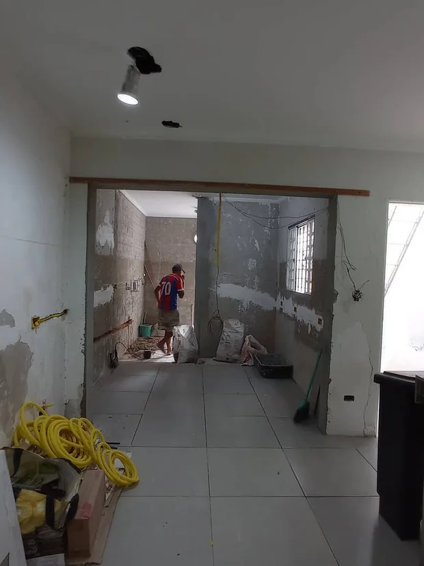 Vãos abertos entre os ambientes durante a obra, com fiação amarela no chão.