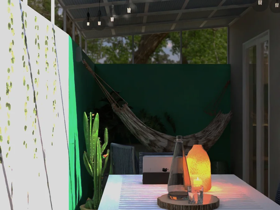 Área gourmet externa com pergolado, mesa, rede e parede verde.