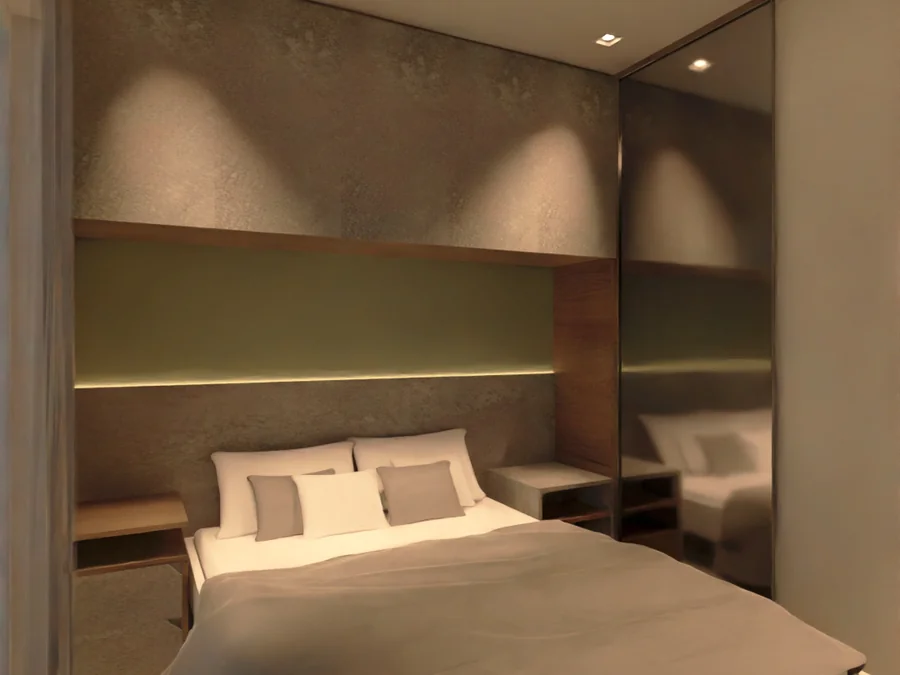 Quarto de casal com cabeceira estofada, iluminação embutida e marcenaria clara.