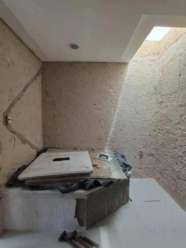 Banheiro em obra, com alvenaria à vista e a banheira posicionada.