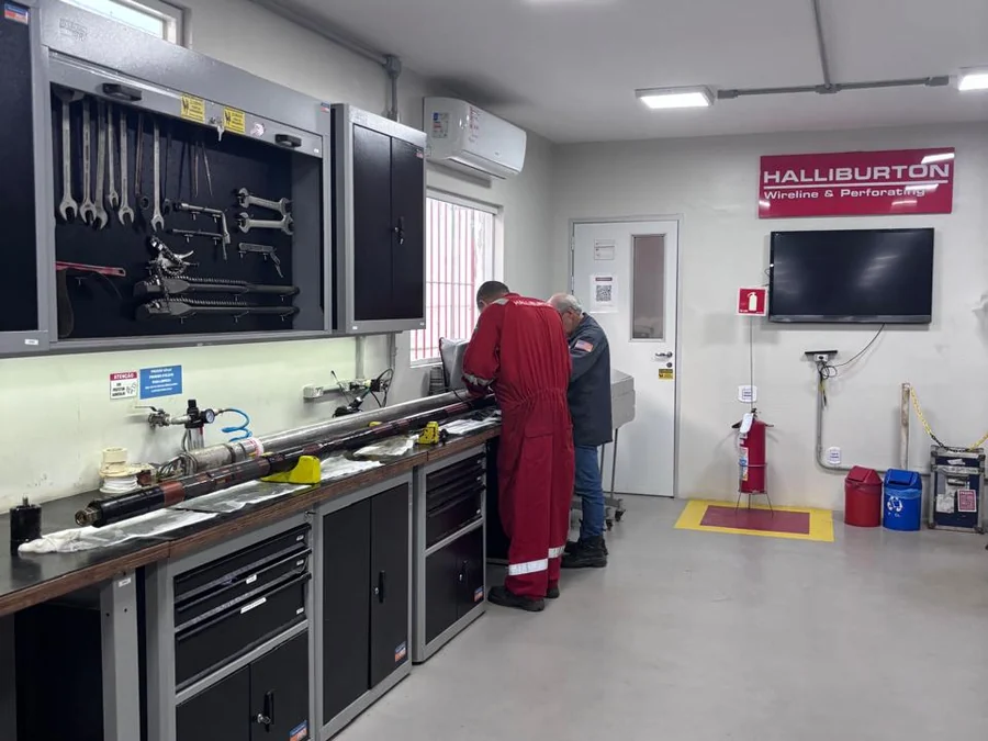 Bancada de trabalho com painel de ferramentas e a equipe em operação.